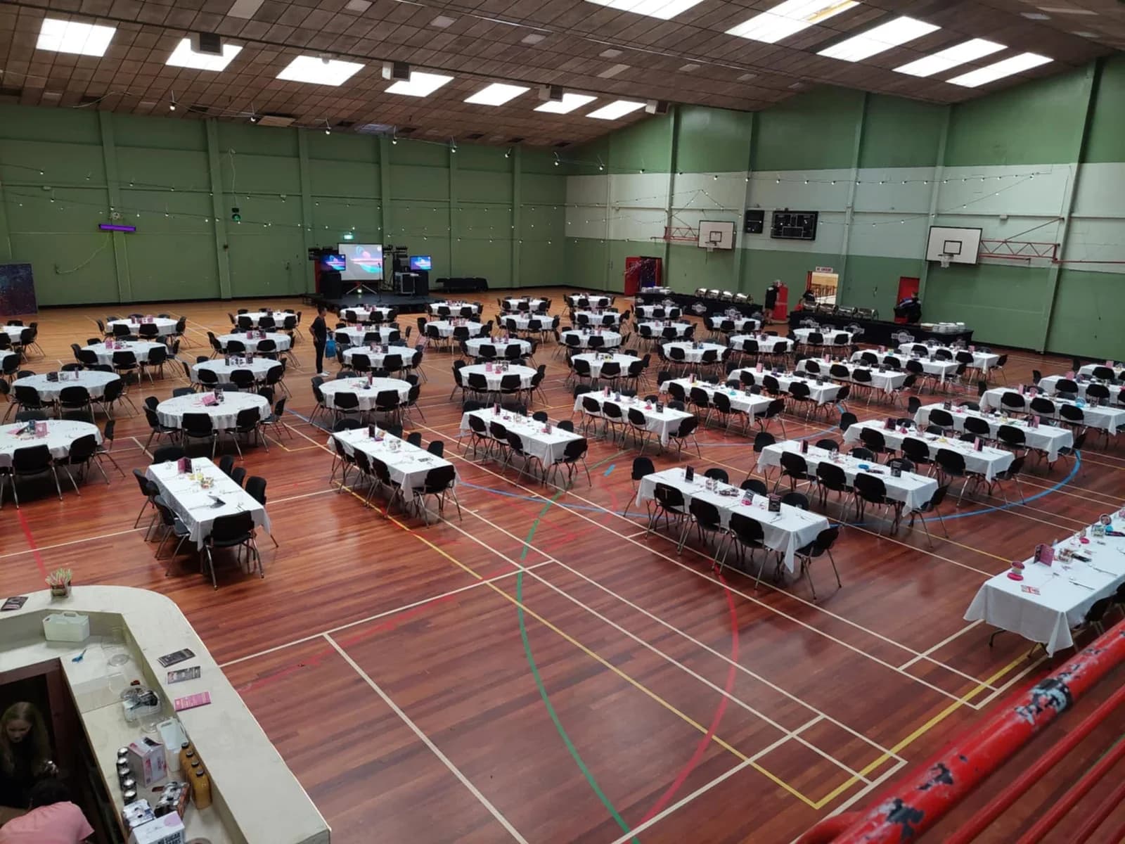 A dinner venue set with round tables, with CFE’s custom-made bar in the foreground on the left