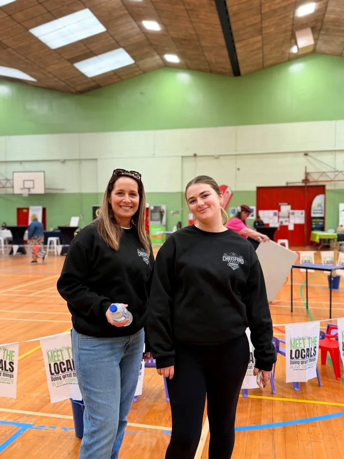 Two women wearing CFE shirts in an event hall